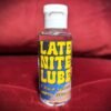 Bottle with Late Nite Lube logo, red velvet background.